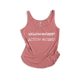 May include: A dusty rose tank top with the words "VISION BOARD" and "ACTION BOARD" in white script. The top has a scoop neck and a curved hemline, perfect for casual wear.