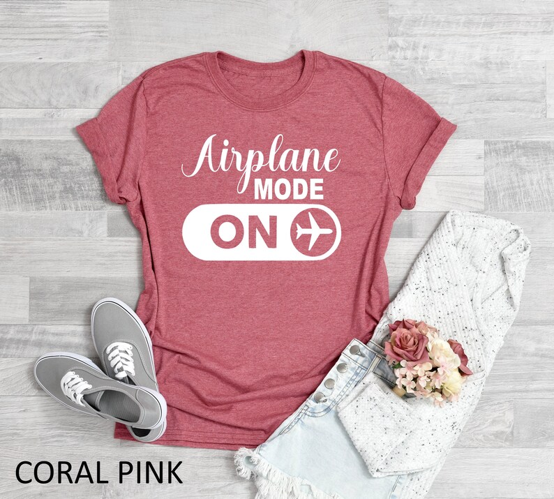 May include: Coral pink t-shirt with the text "Airplane Mode ON" and a white airplane icon.