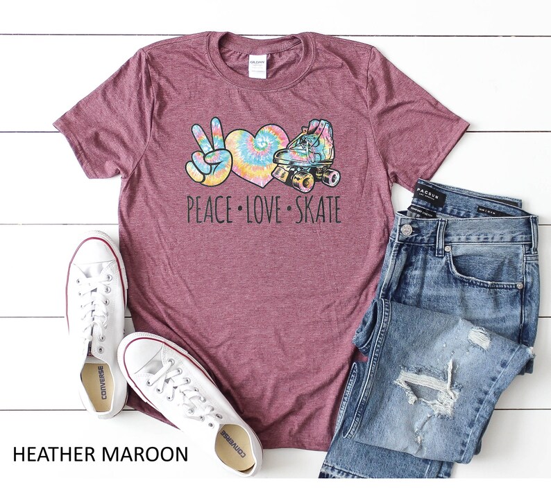 May include: Heather maroon t-shirt with a peace sign, heart, and roller skate graphic. The graphic is in tie-dye colors. The text "Peace Love Skate" is printed below the graphic.