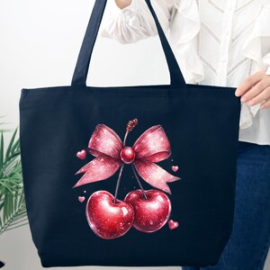 May include: A navy blue tote bag featuring a vibrant illustration of two cherries and a pink bow. The cherries are a deep red with sparkling highlights, and the bow is adorned with glitter. Small pink hearts are scattered around the design.