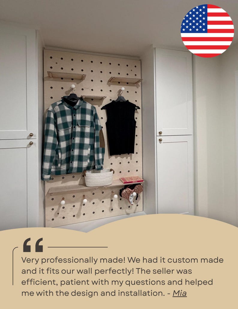 May include: A light-colored wooden pegboard wall organizer featuring multiple circular holes, adjustable shelves, and round pegs. The board displays a green and white plaid shirt, a black sleeveless top, a white woven basket, and a pair of ears.