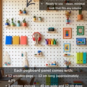 May include: A white pegboard with a black dot pattern, showcasing small potted plants, framed art, and office supplies on wooden shelves. The pegboard includes 12 wooden pegs (12 cm) and 3 shelves (40 cm x 12 cm).