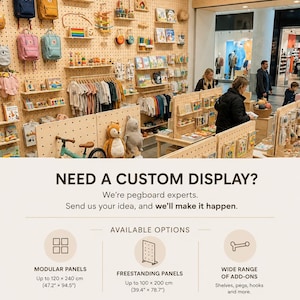 May include: A large light-colored wooden pegboard wall display featuring various shelves, hooks, and pegs holding backpacks, children's clothing, books, and toys. The display includes text advertising custom modular and freestanding panel options.