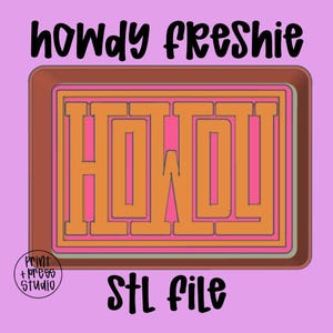 Peut inclure: Conception graphique avec les mots "howdy freshie" en script noir au-dessus d'un motif rectangulaire. Le motif présente le mot "HOWDY" en orange et rose, avec le texte "STL file" en dessous.