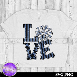 Pode incluir: Camiseta branca com um design "LOVE" listrado em azul e branco. O "O" de LOVE é um pompom azul e branco.
