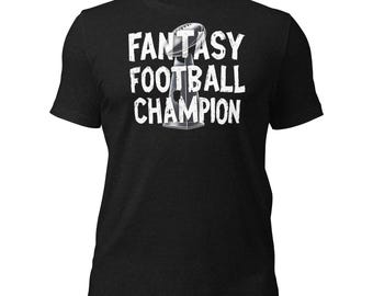 Op de afbeelding: Zwart T-shirt met witte tekst die "Fantasy Football Champion" zegt en een afbeelding van een voetbaltrofee.