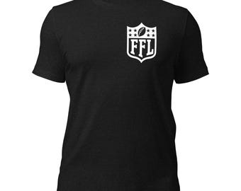 May include: Black short-sleeved t-shirt with a white graphic on the left chest. The graphic is a shield shape with the letters "FFL" inside, a football, and stars. The shirt is made of a soft material.