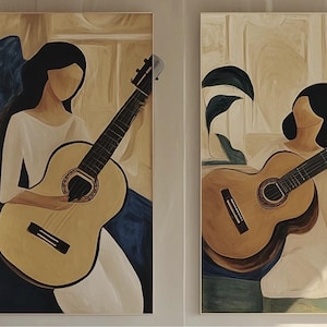 May include: Two framed abstract paintings. Each features a faceless figure in a white dress holding a classical guitar. The guitars are light brown with black strings. The background has neutral tones with blue and beige accents.
