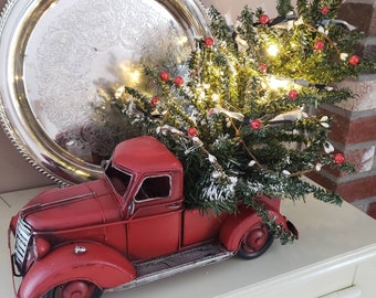 Red truck with lighted Christmas tree.
