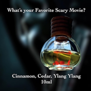 May include: A small glass bottle with a wooden lid filled with a yellow liquid. The bottle is labeled "Cinnamon, Cedar, Ylang Ylang 10ml".
