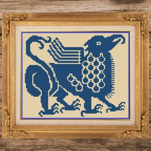 May include: A framed cross-stitch embroidery featuring a blue griffin with an intricate design. The griffin is a mythical creature with the head and wings of an eagle and the body of a lion.