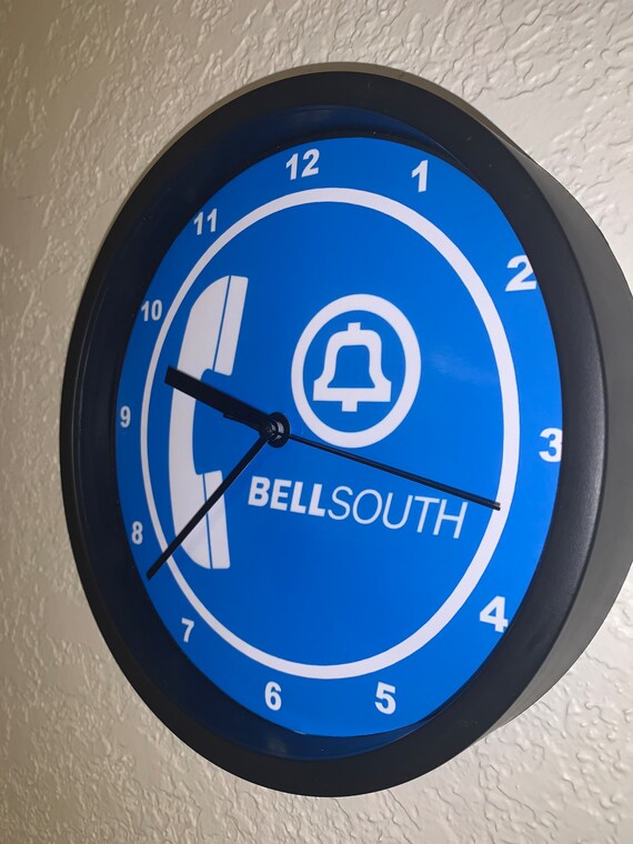 Letrero de reloj negro con publicidad de la compañía telefónica