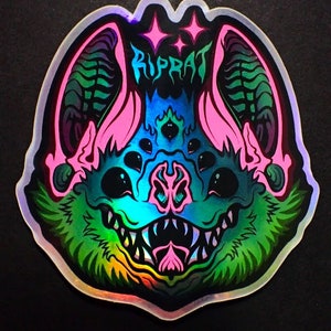 May include: Holographic sticker featuring a stylized bat with multiple eyes and sharp teeth. The bat has pink ears and accents, with the word "RIPRAT" in teal. The design incorporates shades of green, blue, and pink.