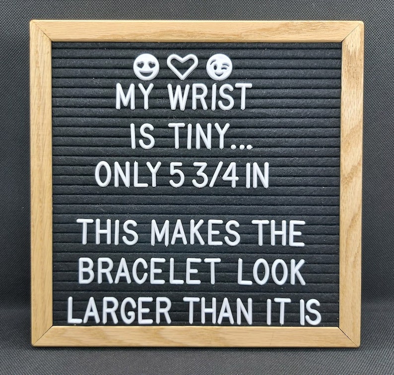 May include: A black letter board with a white wooden frame. The board displays the text "MY WRIST IS TINY... ONLY 5 3/4 IN THIS MAKES THE BRACELET LOOK LARGER THAN IT IS".