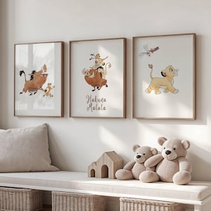 Puede incluir: Tres láminas de pared enmarcadas con personajes de dibujos animados de El Rey León. La lámina izquierda muestra un jabalí y una suricata. La central muestra un jabalí, una suricata y un cachorro de león con el texto Hakuna Matata. La derecha muestra un cachorro de león.