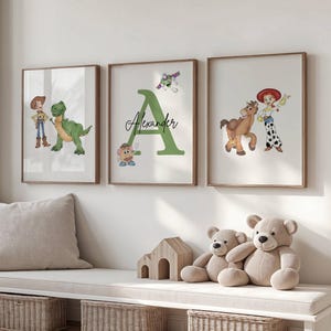 May include: Three framed prints with cartoon characters. The first print shows a cowboy and a green dinosaur. The second print has a large green letter "A" with the name "Alexander" and cartoon characters. The third print shows a cowgirl and a horse. The prints are in a room with a bench and toys.