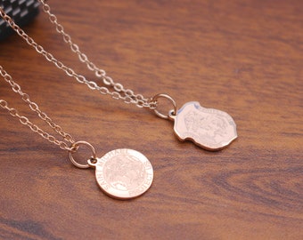 May include: Two gold necklaces with pendants. One pendant is round and says "Saint Michael Protect Us". The other pendant is a shield shape with an image of an angel.