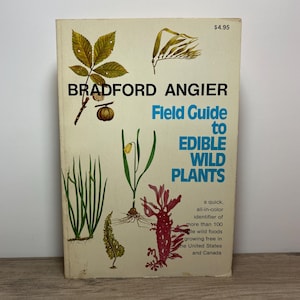 May include: A book cover with a yellow background and the title "Field Guide to Edible Wild Plants" by Bradford Angier. The cover features illustrations of various plants, including a leafy branch, a flower, and a seaweed.