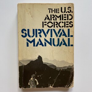 May include: A vintage paperback book titled "The U.S. Armed Forces Survival Manual". The cover features a black and white image of a person standing in a mountainous landscape.