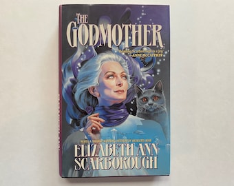 May include: A book cover with a purple background featuring a woman with long white hair and a purple scarf. She is holding a small, gray cat in her arms. The book title is "The Godmother" and the author is "Elizabeth Ann Scarborough".