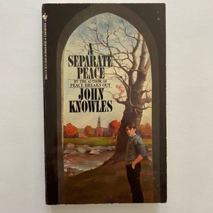 May include: A book cover featuring a dark green background with a large window depicting a tree and a young man standing in front of it. The book title is "A Separate Peace" by John Knowles.