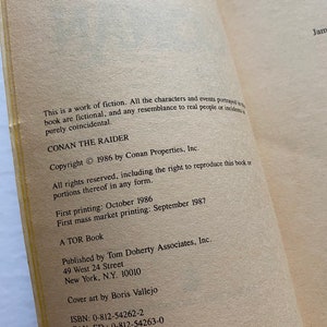 Może przedstawiać: Okładka książki z tytułem "Conan Złodziej" i nazwiskiem autora. Książka została wydana przez Tom Doherty Associates, Inc. i posiada datę praw autorskich z 1986 roku.