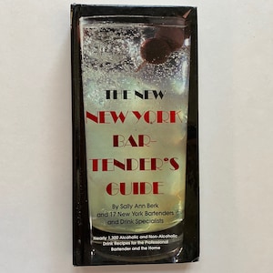 May include: A vintage book cover with a red and white title "The New New York Bar-Tender's Guide" with a glass of liquid and a cherry on a stick in the background.