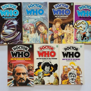 May include: A collection of eight Doctor Who paperback books featuring different covers with illustrations of the Doctor and various characters from the show. The titles include "And the Giant Robot", "And the Armageddon Factor", "And the Underworld", "And the Tenth Planet", "And the Doomsday Weapon", "And the Revenge of the Cybermen", and "And the Day of the Daleks".