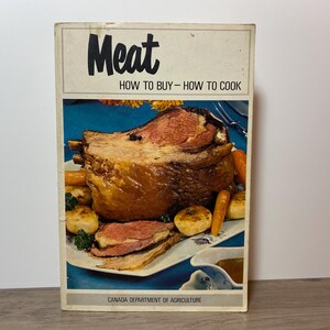 May include: Vintage cookbook titled "Meat" with the subtitle "How to Buy - How to Cook." The cover features a photograph of a roasted meat dish with vegetables. The book is published by the Canada Department of Agriculture.