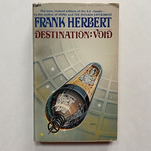 May include: A vintage paperback book cover with a futuristic illustration of a spaceship with a person inside. The book title is "DESTINATION: VOID" and the author is "FRANK HERBERT".