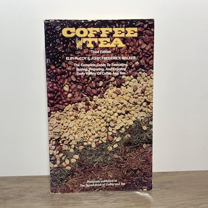 May include: A book titled "Coffee and Tea" with a cover featuring coffee beans and tea leaves. The title is in gold lettering. The book is a guide to evaluating, buying, preparing, and enjoying coffee and tea.