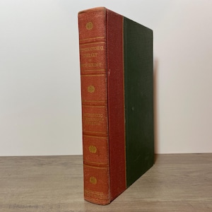 May include: A vintage book with a red spine and cover, featuring gold lettering that reads "International Library of Psychology". The book's other side is green. The book is likely a collectible or antique item.
