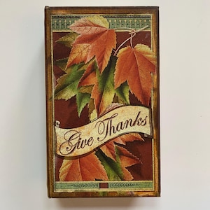 May include: A brown wooden box with a vintage design featuring fall leaves and the text "Give Thanks".