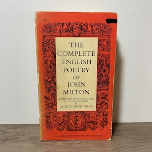 May include: A vintage paperback book titled "The Complete English Poetry of John Milton." The book has a red cover with ornate illustrations and the title in large, bold letters. The book is part of the Anchor Seventeenth-Century Series.