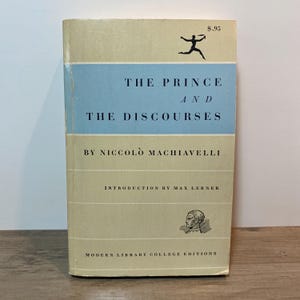 May include: A vintage book titled "The Prince and The Discourses" by Niccolò Machiavelli. The book has a light blue and beige cover with black text. The cover features a running figure and the price £0.75.