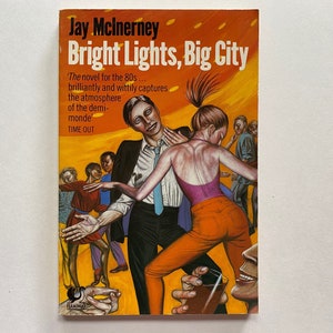 May include: A book cover with a yellow and orange background featuring a painting of people dancing. The title of the book is "Bright Lights, Big City" by Jay McInerney. The text "The novel for the 80s... brilliantly and wittily captures the atmosphere of the demi-monde" is printed below the title. The text "TIME OUT" is printed below the quote.