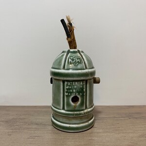 以下が含まれることがあります： 円筒形のボディとドーム型のトップを備えた、ヴィンテージの緑色のセラミックランプホルダー。 ランプホルダーには小さな穴と、ほつれた端のある茶色のコードが付いています。 「PATENTED MAR 21 1911 AUG 8 1911 MAYER 9 1911」の文字が見えます。