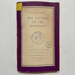 Peut inclure: Une couverture de livre de couleur crème et violette avec le titre "La Nature de l'Univers" de Lucrèce. La couverture présente une illustration en noir et blanc d'une tête d'homme et un prix de 75 cents.