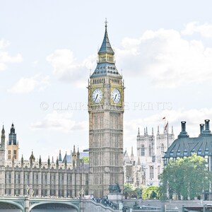 May include: A view of Big Ben, the iconic clock tower of the Houses of Parliament in London, England. The tower is a pale yellow with a dark blue roof and a clock face with Roman numerals. The tower is surrounded by other buildings, including the Houses of Parliament and Westminster Abbey.