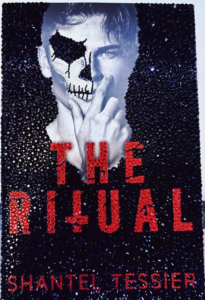 May include: A black and white image featuring a person with a skull design on their face. The text "THE RITUAL" is in red, along with the author's name, "SHANTEL TESSIER". The image is embellished with black and silver accents.