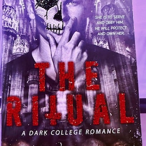 May include: Book cover for "The Ritual: A Dark College Romance" by Shantel Tessier. The cover features a man with a skull design on his face, with the title in large, red, glittery letters. The background is a dark, gothic-style image.