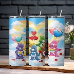 Pode incluir: Três canecas de aço inoxidável com desenhos dos Ursinhos Carinhosos. Cada caneca apresenta um personagem diferente dos Ursinhos Carinhosos contra um fundo de céu com nuvens e balões. As canecas têm uma tampa prateada e um canudo.