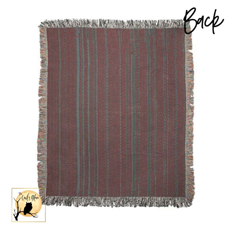 May include: A woven throw blanket with a fringed border. The blanket has a striped pattern in shades of pink and green.