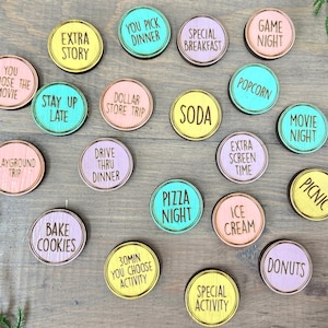 Puede incluir: Un conjunto de 18 c&iacute;rculos de madera coloridos con varias actividades escritas en ellos. Los c&iacute;rculos son en tonos de rosa, amarillo, azul y verde. El texto en los c&iacute;rculos incluye "T&uacute; eliges la pel&iacute;cula", "Quedarse despierto hasta tarde", "Historia extra", "T&uacute; eliges la cena", "Viaje a la tienda de un d&oacute;lar", "Cena para llevar", "Hornear galletas", "30 minutos T&uacute; eliges la actividad", "Desayuno especial", "Soda", "Noche de pizza", "Noche de juegos", "Palomitas de ma&iacute;z", "Tiempo de pantalla adicional", "Helado", "Actividad especial", "Noche de cine", "Picnic", y "Donuts".