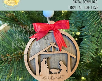 May include: A wooden Christmas bauble featuring a nativity scene with the words "O holy night" at the bottom. The bauble is decorated with a red bow and is hanging on a Christmas tree.