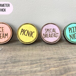 Puede incluir: Cuatro discos redondos de madera de 1,25 pulgadas de di&aacute;metro con fondos de colores diferentes y texto negro. Los discos dicen "Ice Cream", "Picnic", "Special Breakfast" y "Pizza Night".