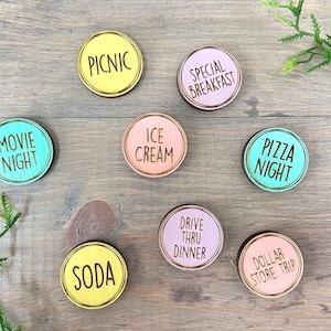 Puede incluir: Ocho c&iacute;rculos de madera con diferentes fondos de colores y texto negro. El texto en los c&iacute;rculos dice: "Movie Night", "Picnic", "Ice Cream", "Special Breakfast", "Pizza Night", "Soda", "Drive Thru Dinner" y "Dollar Store Trip".