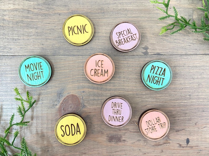 Puede incluir: Ocho c&iacute;rculos de madera con diferentes fondos de colores y texto negro. El texto en los c&iacute;rculos dice: "Movie Night", "Picnic", "Ice Cream", "Special Breakfast", "Pizza Night", "Soda", "Drive Thru Dinner" y "Dollar Store Trip".