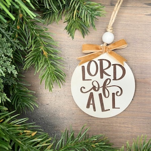 Lord of all ornament with gold ribbon and white bead.
