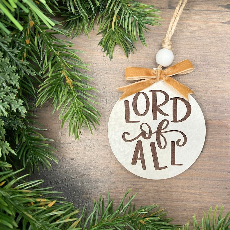Lord of all ornament with gold ribbon and white bead.